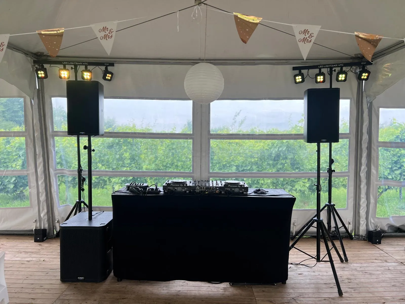 DJ-booth in een feesttent met vlaggetjes en lichtbalken